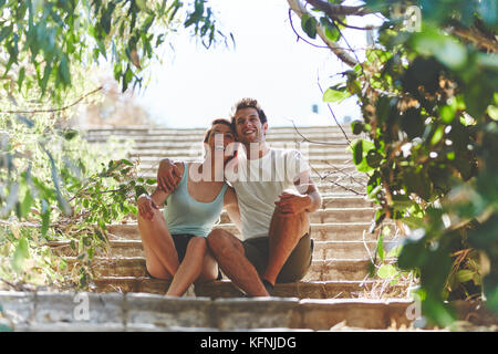 Portrait of happy couple assis sur des escaliers à l'extérieur à l'écart Banque D'Images