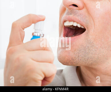 Close-up of a man applying spray haleine fraîche Photo Stock - Alamy