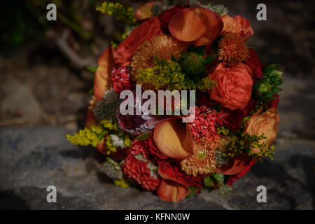 Vin et noir couleurs dans un bouquet de mariage mixte avec mini lis calla flamme chaude, roses rouges et de fleurs sauvages Banque D'Images