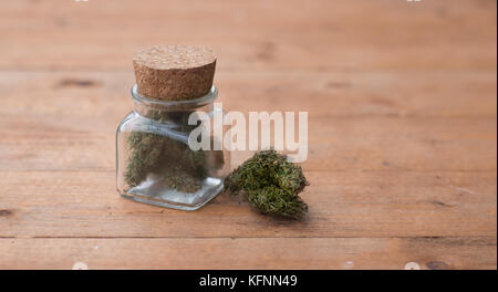 Un pot de la marijuana médicale sur une table en bois. Banque D'Images