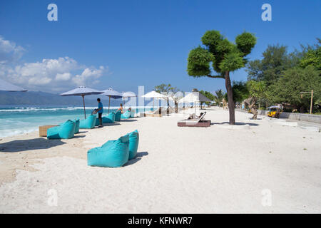 Chaises et parasols sur une plage de sable blanc, Gili Trawangan, Indonésie Banque D'Images