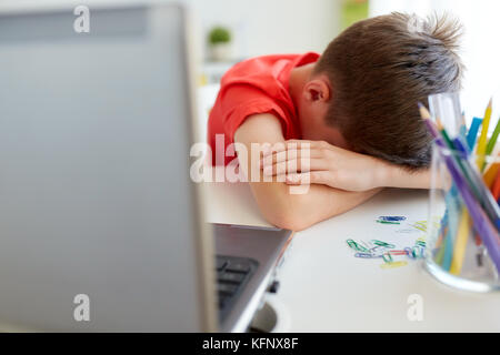 Fatigué ou triste garçon étudiant avec laptop at home Banque D'Images