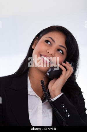 Portrait of young businesswoman talking on telephone Banque D'Images