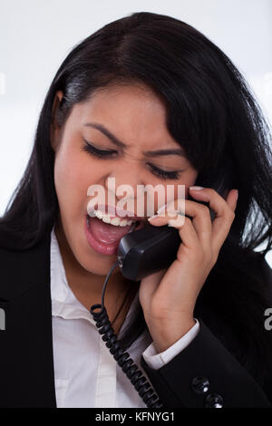 Portrait de femme en colère en criant sur téléphone Banque D'Images