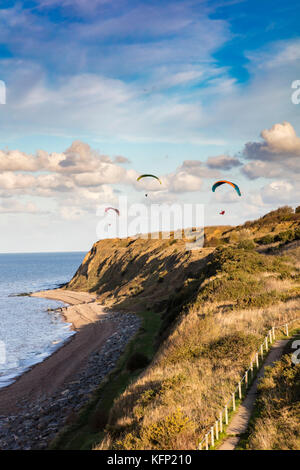 Les planeurs para profiter de la brise de terre qui leur ascenseur au-dessus des falaises à Bishopstone, Herne Bay, Kent, UK Banque D'Images