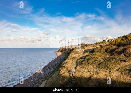 Les planeurs para profiter de la brise de terre qui leur ascenseur au-dessus des falaises à Bishopstone, Herne Bay, Kent, UK Banque D'Images