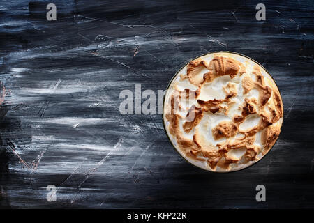 Voir l'ange haut de pudding à la banane fait maison avec de la meringue faite à partir de zéro sur un fond sombre. Banque D'Images