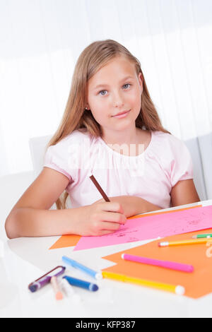 Portrait de jeune fille dessiner avec des marqueurs colorés à la maison Banque D'Images