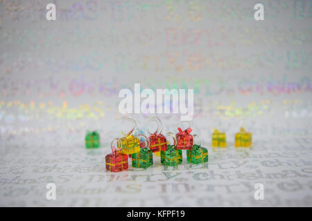 Noël en couleurs photographie image avec petit verre xmas présente avec des cerceaux pour tree hanging décoration avec du papier d'emballage brillant background Banque D'Images