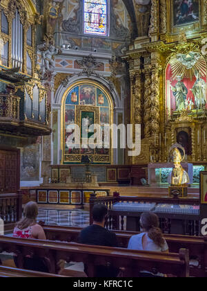 Les visiteurs assis sur les bancs de l'écoute audio les guides à l'intérieur de l'église de San Nicolas (Parroquia de San Nicolas), Ciutat Vella, Valence, Espagne. Banque D'Images