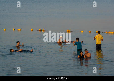 Tôt le matin, l'établissement Holiday Inn Dead Sea beach resort, avec des gens qui flottent dans l'eau salée et de prendre des photos, de la Jordanie, Moyen-Orient Banque D'Images