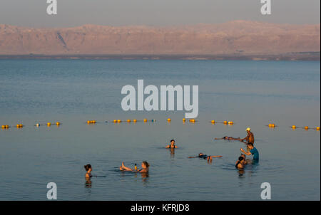 Tôt le matin, l'établissement Holiday Inn Dead Sea beach resort, avec des gens qui flottent dans l'eau salée et de prendre des photos, avec vue de Cisjordanie, Jordanie, Moyen-Orient Banque D'Images