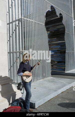 Une jolie femme jouant banjo près de l'exécution de busker Ai Weiwei installation dans Washington Square Park à Greenwich Village, New York City. Banque D'Images