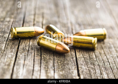 Balles de pistolet 9 mm sur la vieille table en bois. Banque D'Images