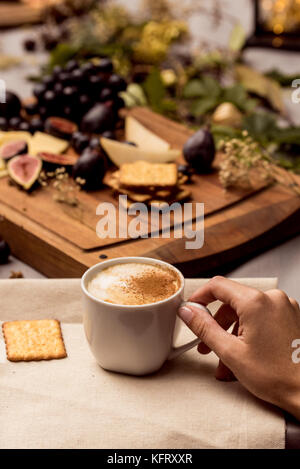 Mains courantes tasse de café avec de la nourriture en arrière-plan Banque D'Images