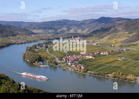 Bateau de croisière passe Dürnstein sur le Danube dans la Wachau - un site du patrimoine mondial - avec des vignobles aux couleurs d'automne jaune et orange, basse-Autriche Banque D'Images