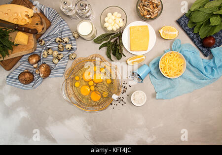 Des ingrédients frais généraux la frittata végétarienne quishe diet meal. Oeufs dans le bol, des oeufs de cailles, lait, fromage mozzarella, gouda, tomates, épinards, champignons, ch Banque D'Images