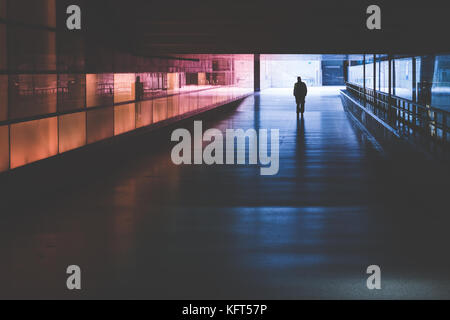 Silhouette d'une personne qui marche dans un tunnel noir Banque D'Images