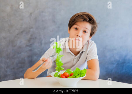 Cute teen boy n'aimez eating salad Banque D'Images