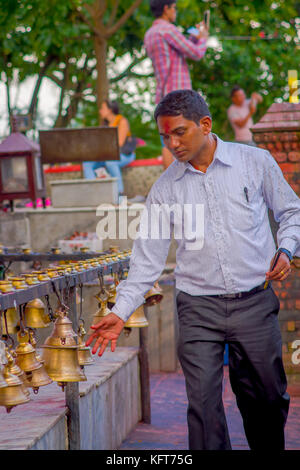 Pokhara, Népal, 10 octobre 2017 non identifié : businessman touching les cloches de tailles différentes en barahi taal mandir, Pokhara, Népal Banque D'Images