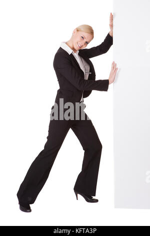 Businesswoman poussant bannière. Isolé sur fond blanc Banque D'Images