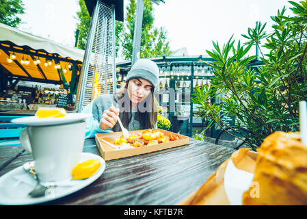 Belle femme manger en café à l'extérieur Banque D'Images