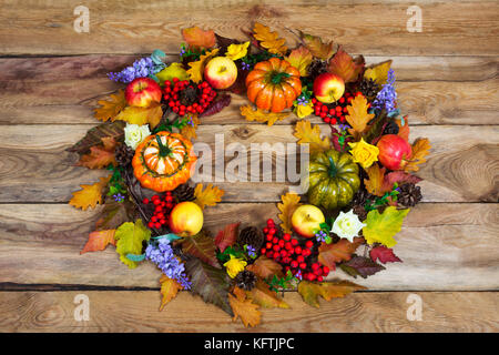 Couronne de porte de grâce avec des feuilles d'automne, citrouilles, pommes, cônes, lilas fleurs et fruits mûrs Rowan, vue du dessus Banque D'Images