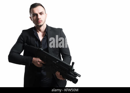 L'homme isolé sur un fond blanc avec un revolver qu'il se retourne et vise l'appareil photo Banque D'Images