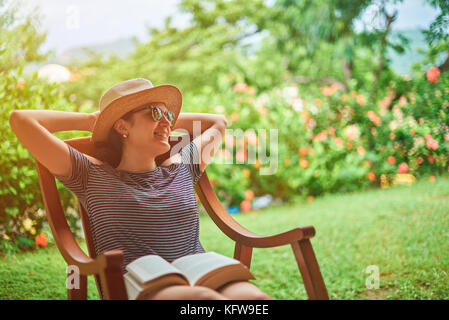 Heureux à l'aise jeune femme en terrasse aux beaux jours d'été contexte Banque D'Images