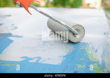 La peinture d'une surface en métal avec peinture apprêt à l'aide d'un rouleau, Close up Banque D'Images