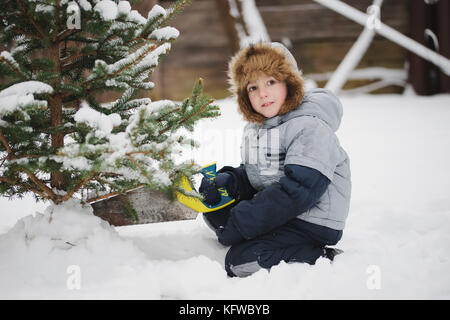 Garçon avec des grumes de sciage à façon arbre de Noël Banque D'Images