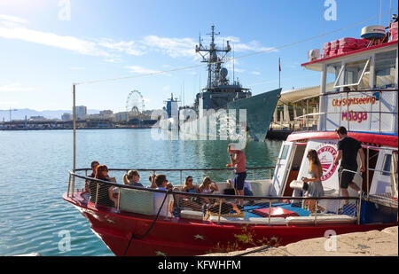 Bateau de tourisme de quitter le port de Malaga, deux navires de guerre en arrière-plan, Andalousie, Espagne Banque D'Images