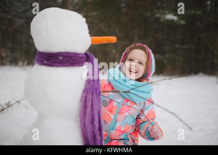 Elle prépare le Snowman dans winter park Banque D'Images