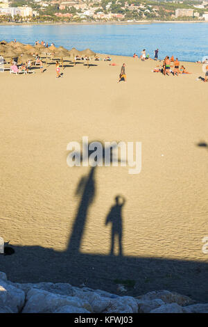 Ombre de l'homme à la plage de Malagueta, Malaga, Costa del Sol, Andalousie, Espagne Banque D'Images