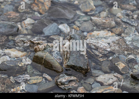 Cailloux dans une claire au lac Wanaka dans queentown nz - j'aime à appeler cette image dans la moitié et la moitié en raison de l'eau jusqu'à mi-hauteur sur les cailloux. Banque D'Images