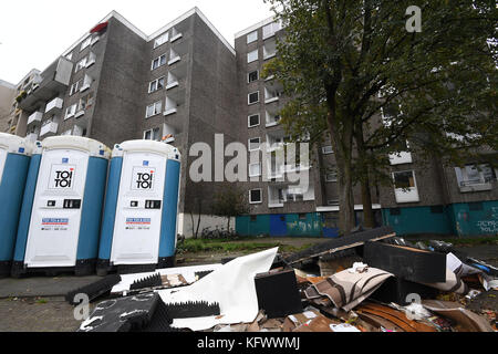 Delmenhorst, Allemagne. 01 novembre 2017. Des ordures et des toilettes mobiles peuvent être aperçues devant un immeuble d'habitation dans le quartier résidentiel 'Wollepark' à Delmenhorst, Allemagne, le 1er novembre 2017. Ce bloc de logement et deux autres blocs ne sont pas autorisés à être habités et ont donc été verrouillés. Auparavant, les bâtiments, composés chacun de 80 appartements, avaient été déclarés inhabitables par la ville en raison de déficiences. Crédit : Carmen Jaspersen/dpa/Alamy Live News Banque D'Images