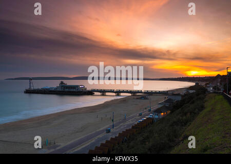 Bournemouth, Dorset, UK. 1er novembre 2017. Météo britannique. Le soleil se couche derrière une banque de nuages vu de front de mer de Bournemouth à l'ouest à travers la jetée vers Poole. Crédit photo : Graham Hunt/Alamy Live News Banque D'Images