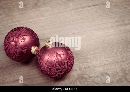 Deux boules de Noël isolées sur fond de bois. Boules en verre décorées. Banque D'Images