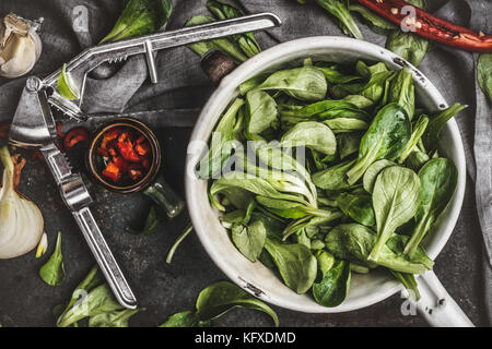 Salade verte feuilles en passoire vintage sur table de cuisine rustique, vue du dessus Banque D'Images