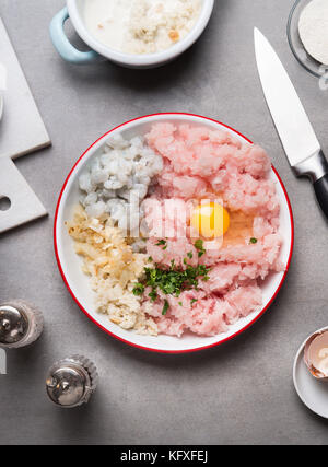 Croquettes de poisson préparation avec émincé de poisson, crevettes, oeuf oignon pain trempé , et sur la table de la cuisine avec un couteau, vue d'en haut Banque D'Images