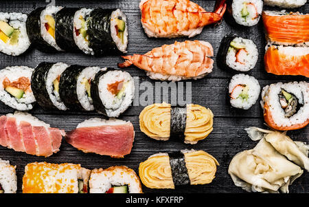 Variété de sushi : maki, nigiri,bobines sur fond de bois sombre, vue du dessus Banque D'Images