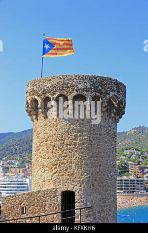 Drapeau Catalan volant au-dessus de la tour ancien fort, Tossa de Mar, Espagne Banque D'Images