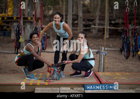 Portrait of smiling friends wearing faisceau dans park Banque D'Images