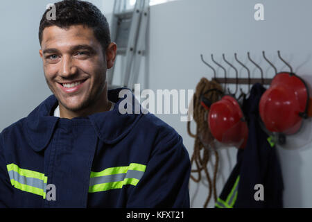 Portrait of smiling fireman standing dans le bureau Banque D'Images