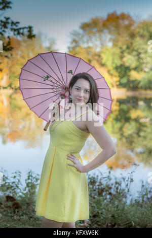 Femme avec un parasol en face d'un ruisseau Banque D'Images