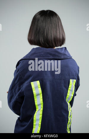 Vue arrière du female architect standing against white background Banque D'Images