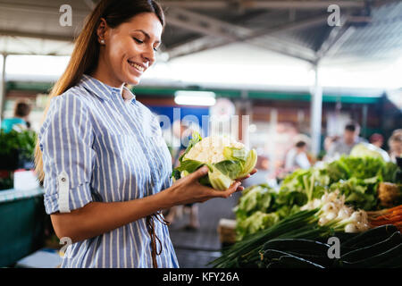 Photo de femme au marché acheter des légumes Banque D'Images