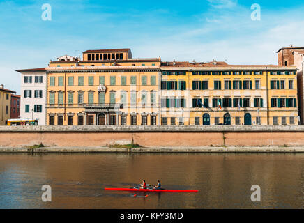 Les rameurs sur la rivière Arno à Pise, Toscane, Italie avec une superbe architecture italienne colorées en arrière-plan Banque D'Images