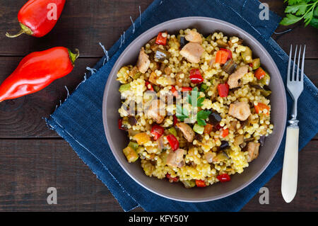 Un régime alimentaire léger avec salade, couscous de légumes (courgettes, aubergines, carottes, poivrons, oignons), les morceaux de poulet sur un fond de bois foncé Banque D'Images