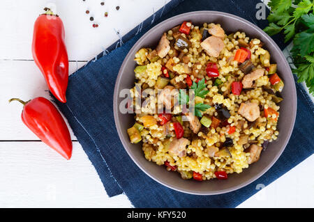 Un régime alimentaire léger avec salade, couscous de légumes (courgettes, aubergines, carottes, poivrons, oignons), les morceaux de poulet sur un bois blanc backgroun Banque D'Images